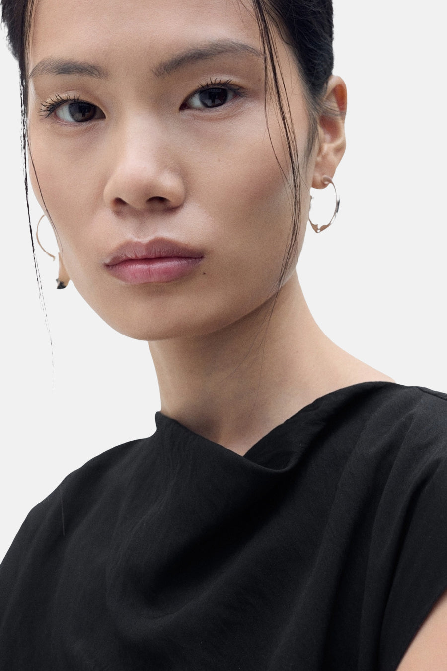 Robe noire de MANGO avec un col drapé et une texture subtile portée par un modèle.