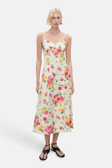 Multikleurige bloemige zomerjurk van MANGO, met dunne bandjes en een smockrug, gedragen met zwarte sandalen.