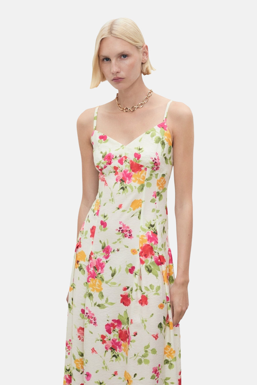 Multikleurige jurk van MANGO, met bloemenprint, dunne bandjes en een gouden ketting.