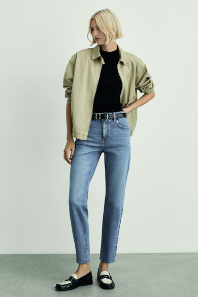 Middelblauwe Mom jeans van MANGO, gedragen met een zwarte riem en tweekleurige loafers.