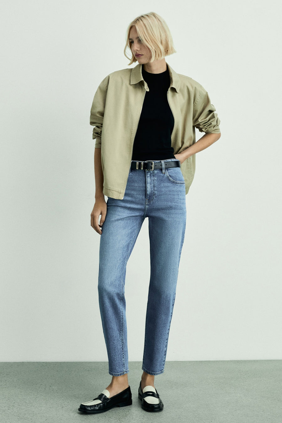 Middelblauwe Mom jeans van MANGO, gedragen met een zwarte riem en tweekleurige loafers.