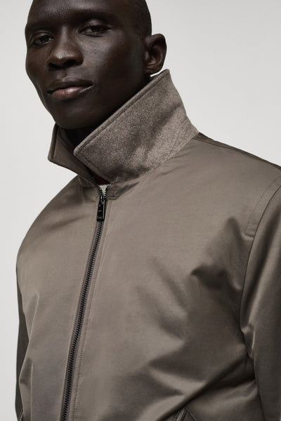 Veste courte marron de MANGO, avec un col en feutre gris et une fermeture éclair visible.