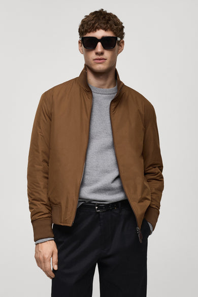 Kort bruin jasje van MANGO, van achteren gezien, met geribde kraag en zoom, gedragen met een zwarte broek.