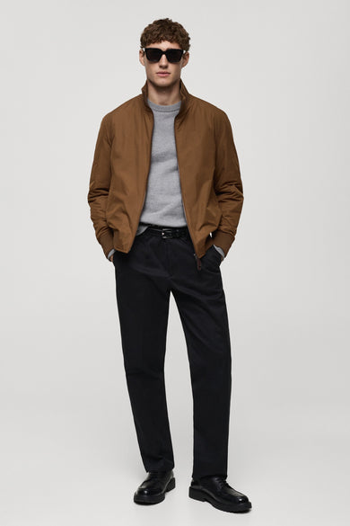Kort bruin jasje van MANGO, gedragen met een grijze trui, een zwarte broek en leren schoenen.
