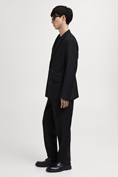 Multikleuren seizoensbroek van MANGO, gedragen met een zwarte blazer en bijpassende leren schoenen, zijwaartse weergave.