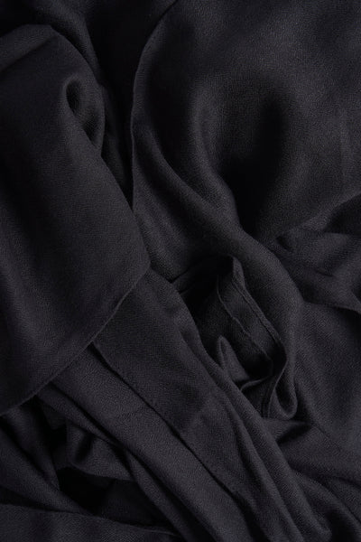 Foulard noir de MANGO, avec une texture légèrement froissée et des plis doux créant un effet drapé.