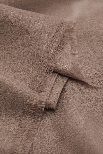 Bruine sjaal van textiel van MANGO, met gerafelde randen en artistieke plooien.