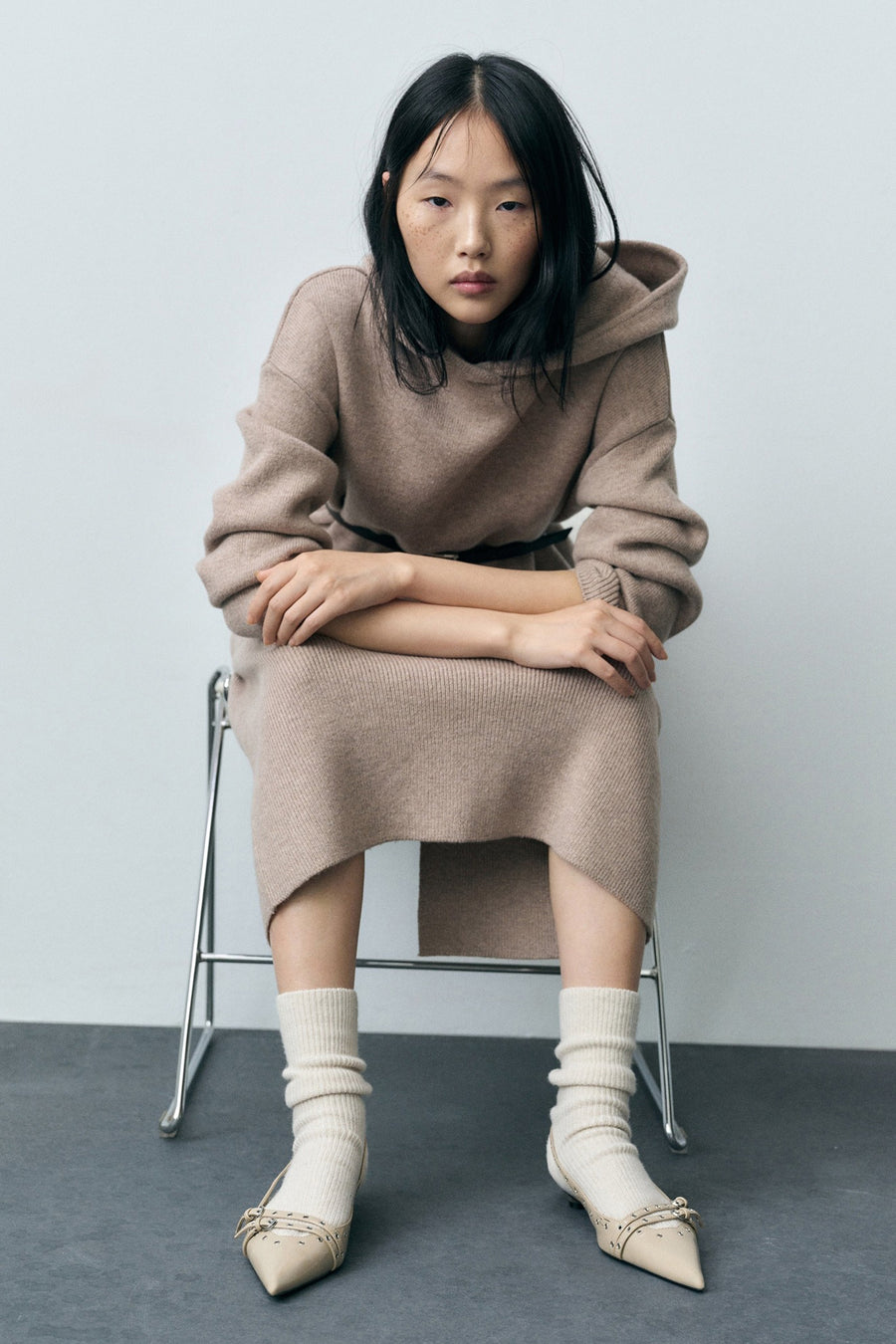 Chaussures plates beiges de MANGO, portées avec des chaussettes en laine côtelée, bout pointu orné d'un nœud.
