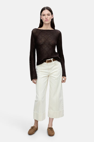 Bruine ronde kraagpull van MANGO, gemaakt van geperforeerd tricot, gedragen met een witte broek en mocassins.