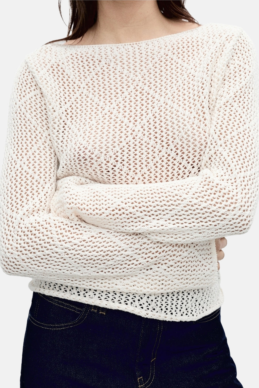 Pull à col rond écru de MANGO, en maille ajourée, porté avec un jean foncé.
