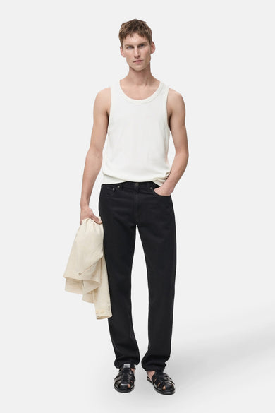 Witte tanktop van MANGO, gedragen met een zwarte jeans en gevlochten leren sandalen.