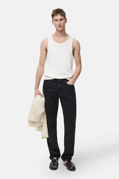 Witte tanktop van MANGO, gedragen met een zwarte jeans en gevlochten leren sandalen.