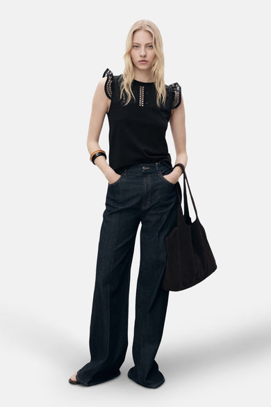 Top noir sans manches de MANGO, avec détails ajourés aux épaules et au col, porté avec un jean ample et un sac.