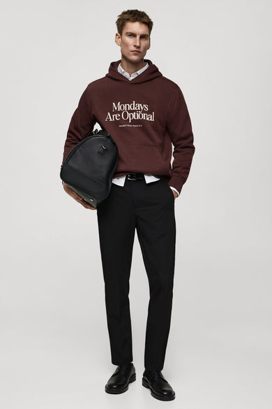 Sweat-shirt bordeaux de MANGO, avec inscription blanche, porté avec un pantalon noir et des chaussures en cuir.