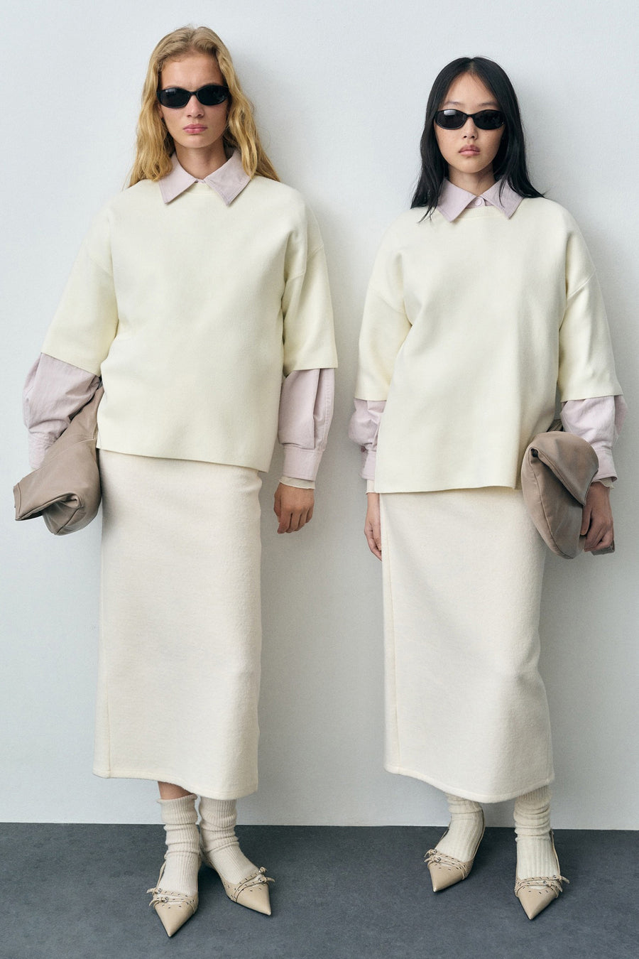 Ecru ronde hals trui van MANGO, gedragen met een kokerrok en beige pumps met versieringen.