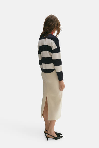 Ronde hals trui van MANGO in blauw met witte horizontale strepen, gedragen met een crèmekleurige midi-rok.