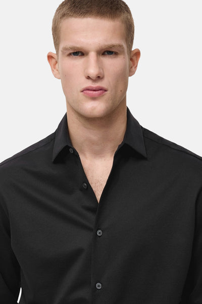 Chemise noire à manches longues de MANGO, avec un col classique et une patte de boutonnage centrale.