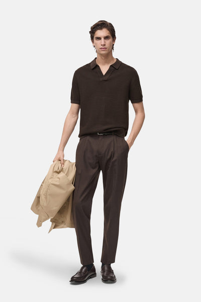Bruin poloshirt met korte mouwen van MANGO, in ribgebreide stof, gedragen met een bruine broek en loafers.