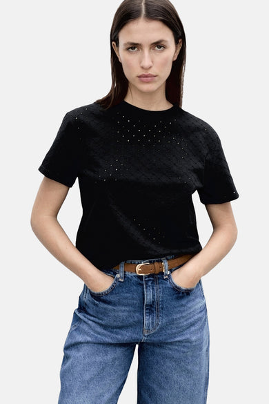 Zwart T-shirt met korte mouwen van MANGO, met geperforeerde patronen, gedragen met een wijde blauwe jeans.