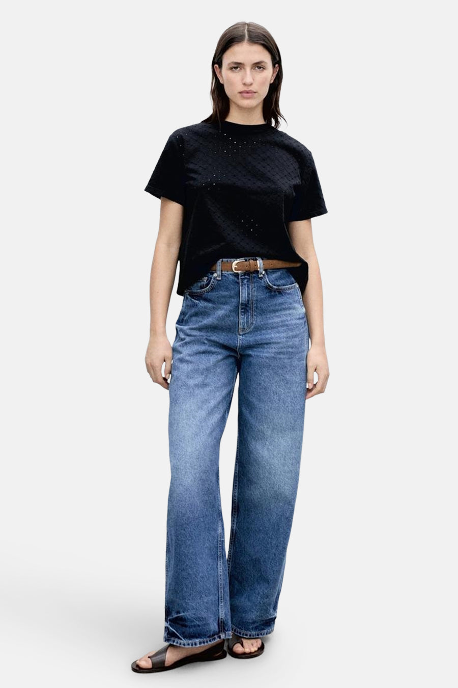 T-shirt noir à manches courtes de MANGO, avec motif en losanges ton sur ton. Porté avec un jean et des sandales.
