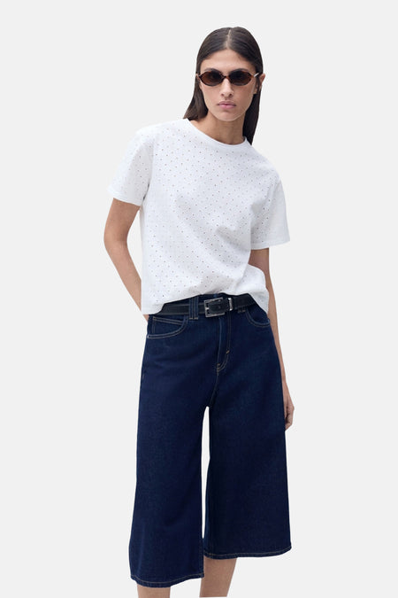 Wit T-shirt met korte mouwen van MANGO, met stippen, gedragen met een wijde broek en een zonnebril.