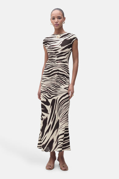 Robe imprimée zébrée de MANGO, avec un col rond, portée avec des sandales à talons couleur chair et un collier doré.