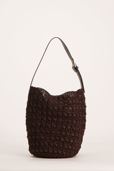 Sac à bandoulière brun de MANGO, en matière tressée avec une bandoulière fine en cuir.
