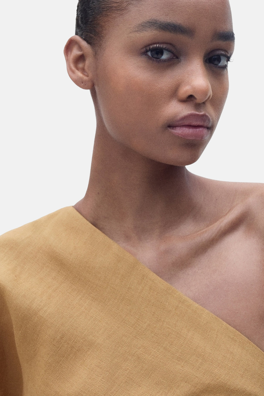 Bruine jurk van MANGO, asymmetrische snit met een getextureerde stof en een blote schouder.