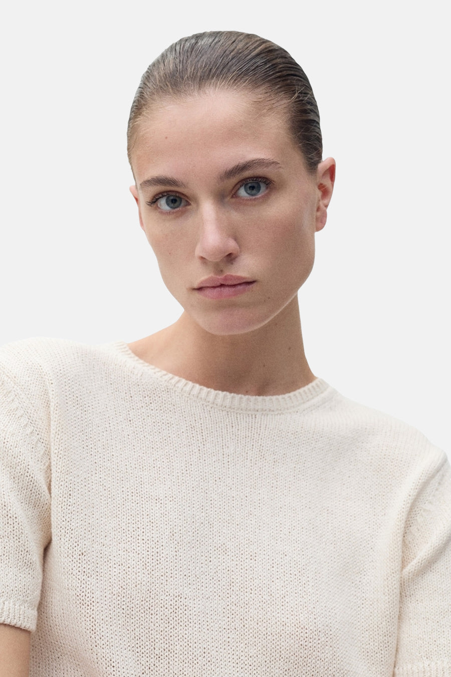 Pull à col rond beige de MANGO, en maille fine, porté par un mannequin au teint clair.
