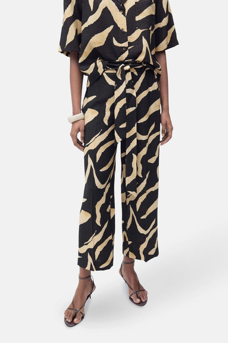 Zwarte broek met golvend patroon van MANGO, gedragen met bijpassende riem en hoge hakken.