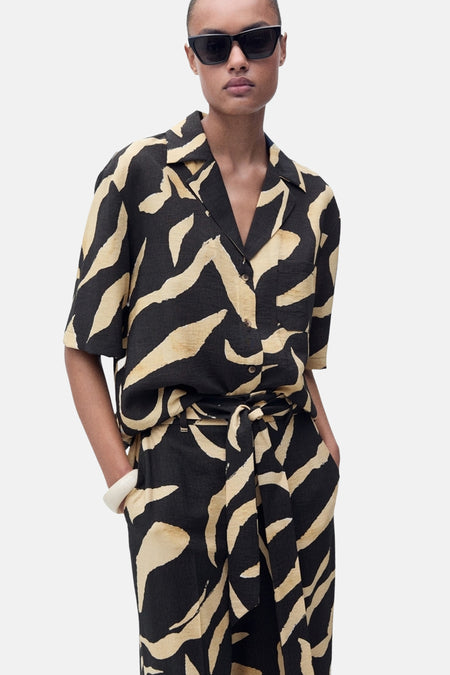 Zwarte broek met golvend patroon van MANGO, met een strikceintuur en een witte band.