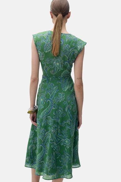 Groene jurk van MANGO, met blauw paisley-patroon, gedragen met een transparante armband, van achteren gezien.