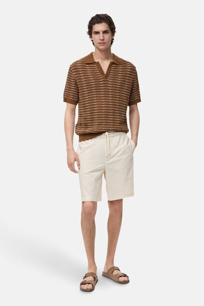 Bruin gestreept poloshirt met korte mouwen van MANGO, gedragen met een beige short en bruine sandalen.