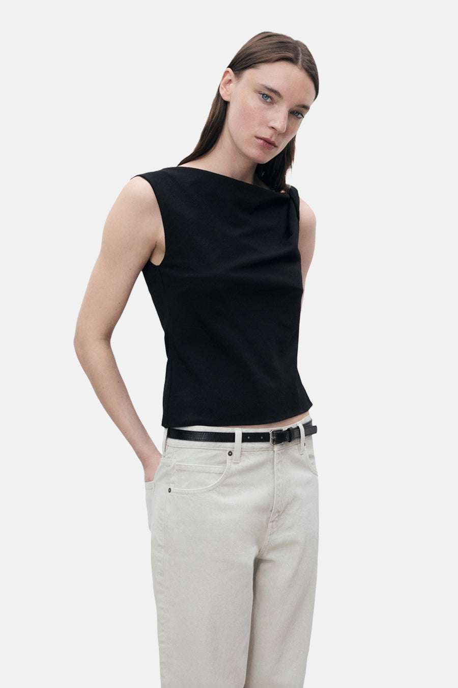 Zwart MANGO hemdje met een geknoopt detail op de schouder, gedragen met een beige broek en een zwarte riem.