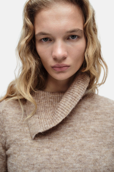 Pull à col roulé beige de MANGO, en maille douce avec col asymétrique et texture chinée.