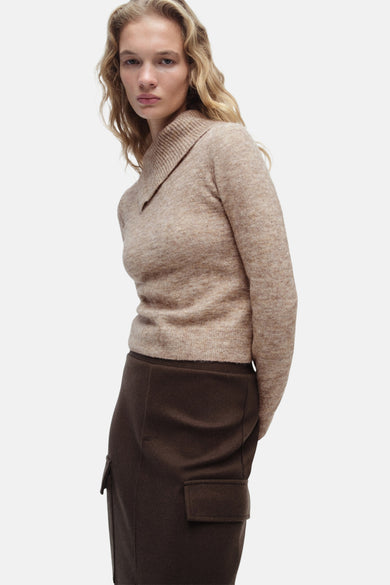 Beige gerollde kraag tr-shirt MANGO,,gedragen met eenbruurrok met poches en lange mouwen.