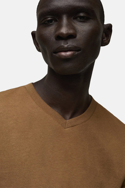 T-shirt à manches courtes brun de MANGO, porté par un homme à la peau foncée, en gros plan.