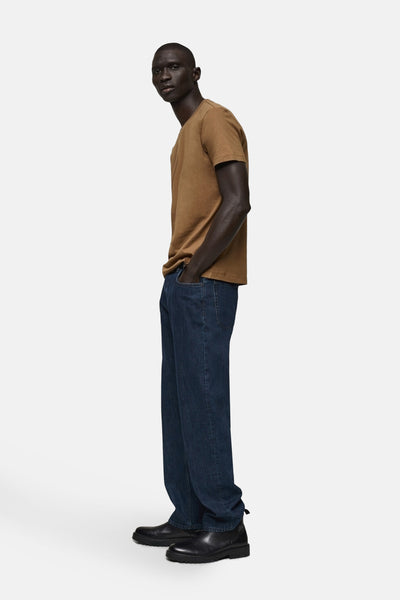 T-shirt brun à manches courtes de MANGO, porté avec un jean bleu foncé et des bottines noires, vue de côté.

