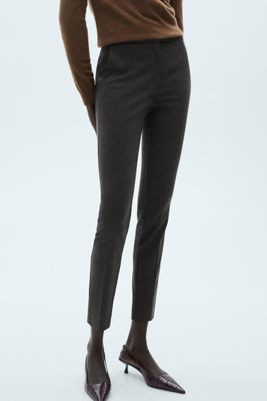 Grijze broek van MANGO, sigarettenmodel, gedragen met een bruine trui en bordeauxrode pumps.