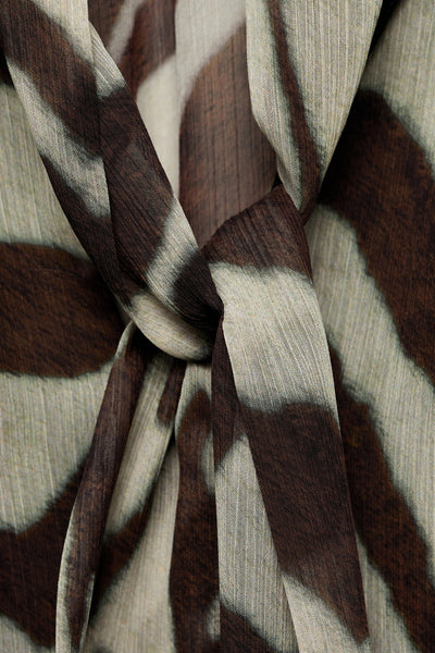 Blouse à manches longues marron de MANGO, motif zébré et texture plissée, nouée sur le devant.