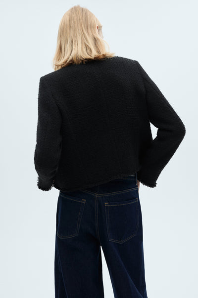 Gilet texturé multicolore de MANGO, porté avec un jean taille haute bleu foncé, vue de dos.
