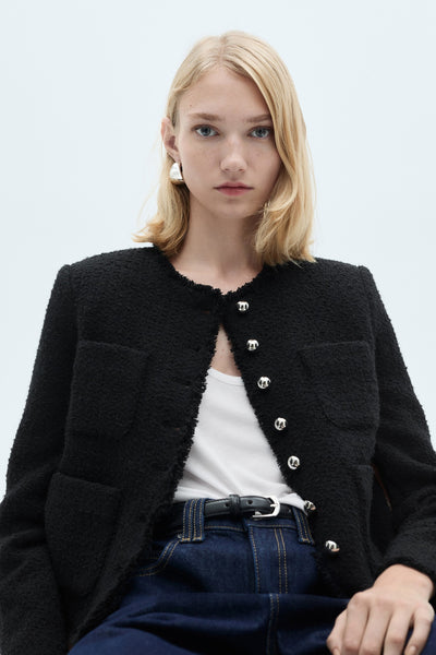 Gilet multicolore de MANGO, en tweed avec des boutons argentés, porté avec un jean taille haute.
