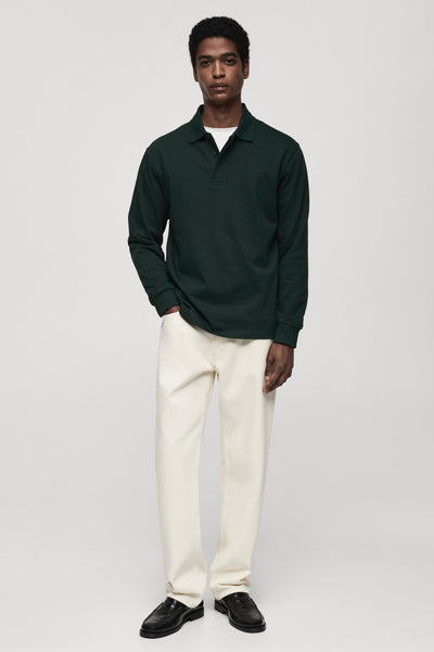 Groene MANGO trui, lange mouwen, gedragen met een wit T-shirt en een lichtbeige broek, zwarte schoenen.