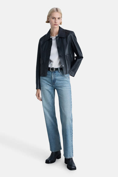 Rechte lichtblauwe jeans van MANGO, gedragen met een zwart leren jasje en een wit T-shirt.