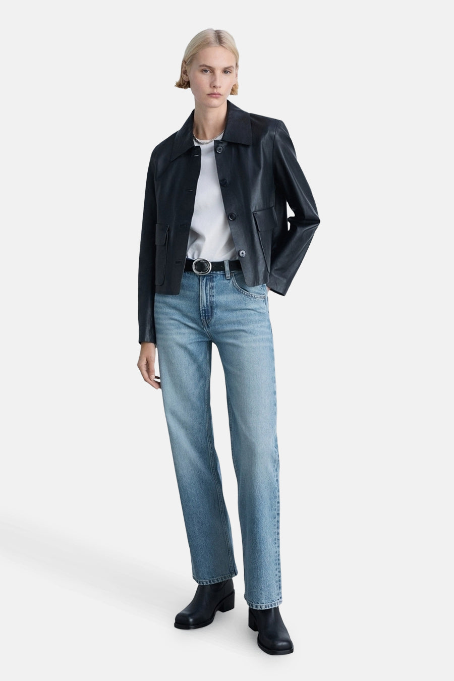Rechte lichtblauwe jeans van MANGO, gedragen met een zwart leren jasje en een wit T-shirt.
