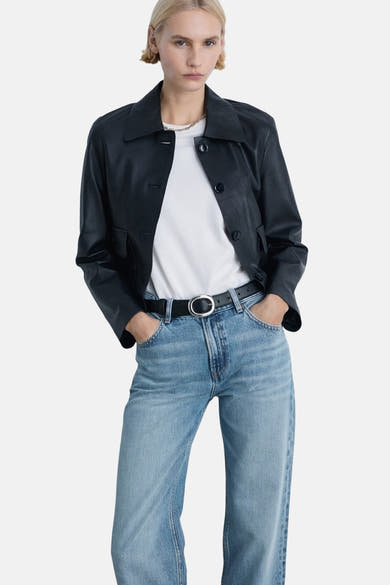 Lichtblauwe rechte jeans van MANGO, gedragen met een zwarte riem en een wit T-shirt.