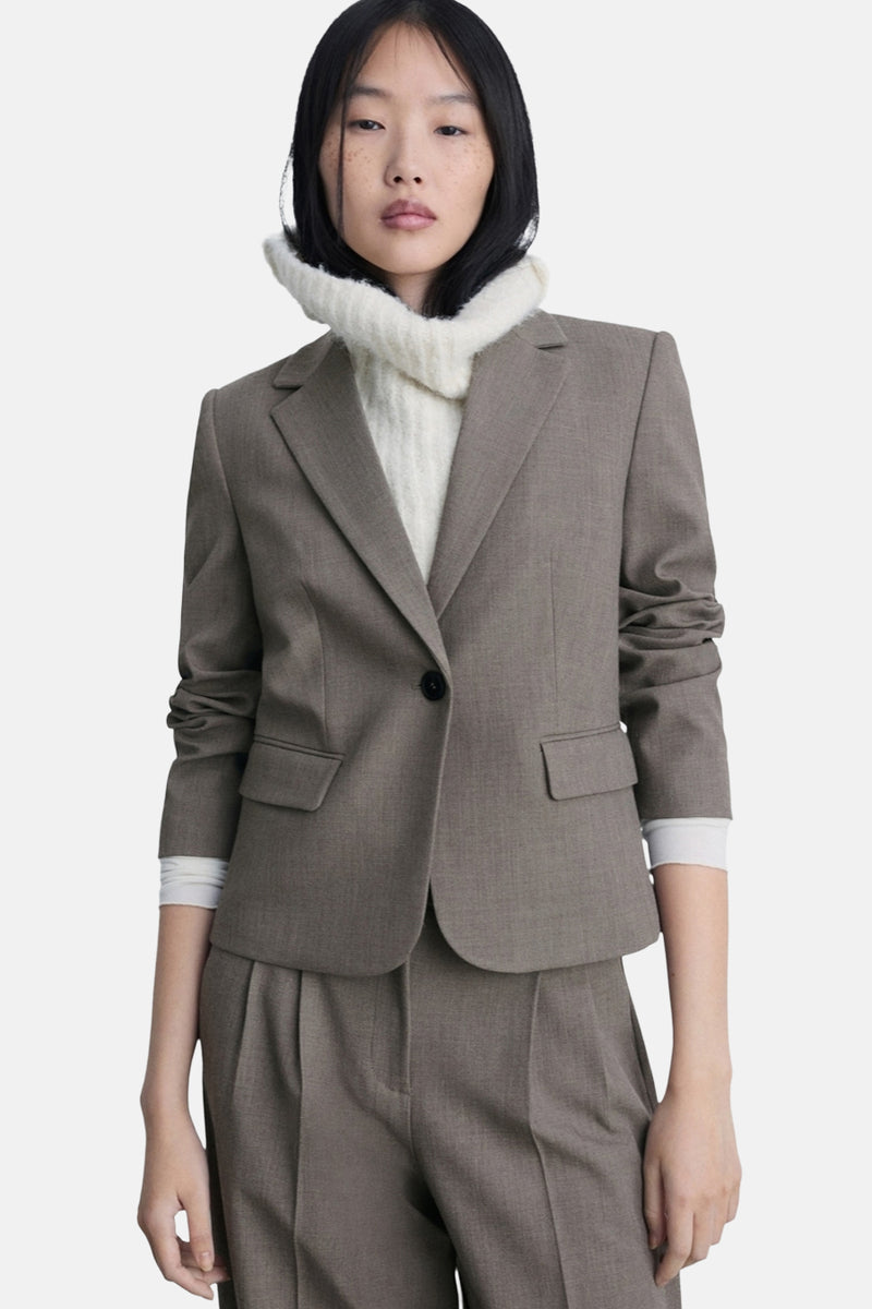 Bruine blazer van MANGO, gedragen met een coltrui van gebreide stof en een bijpassende broek.