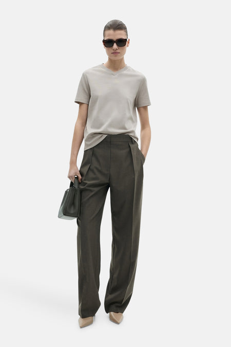 Grijs T-shirt met korte mouwen van MANGO, gedragen met een wijde olijfgroene broek en beige pumps.