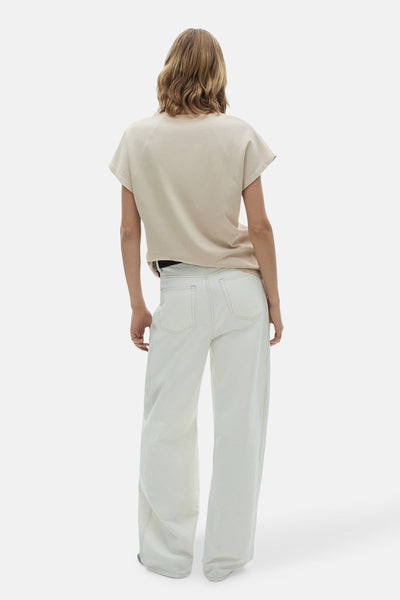 Beige t-shirt met korte mouwen van MANGO, gedragen met een brede taille hoge broek en een zwarte riem.