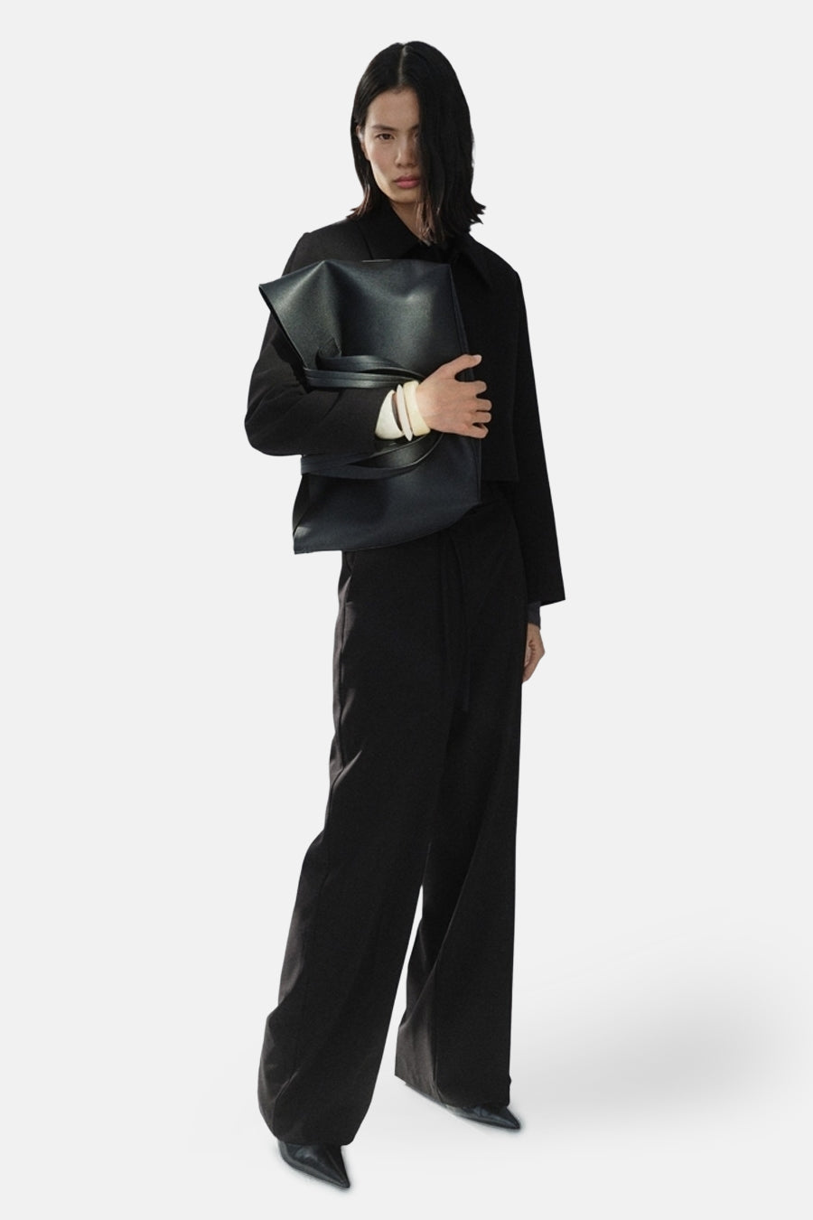 Zwarte pantalon van MANGO, gedragen met een zwart jasje en een oversized handtas.
